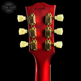Close-up of a red guitar headstock with tuning pegs on a black background, featuring 'Tone Shop' branding.