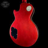 Red electric guitar with Gibson logo on a black background