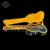 Guitar in an open case with a black background and 'Tone Shop' logo.