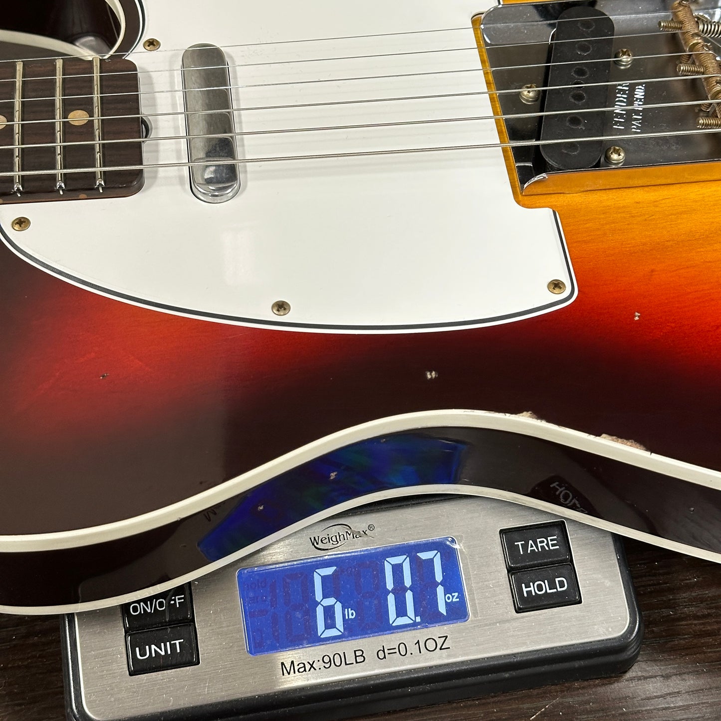 Guitar on a digital scale displaying weight