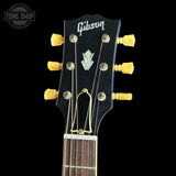 Gibson guitar headstock with tuning pegs on a black background