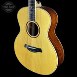 Acoustic guitar with a visible brand logo on a black background