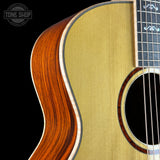 Close-up of an acoustic guitar with a visible brand logo in the corner.