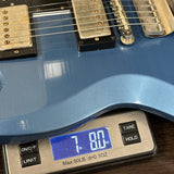 Blue electric guitar on a digital scale displaying weight