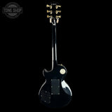 Black electric guitar on a white background with 'Tone Shop' logo.