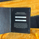 Gibson Custom Certificate of Authenticity inside a guitar case on a wooden surface