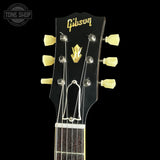 Gibson guitar headstock with tuning pegs on a black background