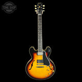 Electric guitar with a sunburst finish on a black background, featuring the Gibson logo.