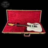 White electric guitar in a red-lined case with 'Tone Shop' logo.