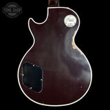 Back of a guitar with a visible brand logo on a black background
