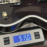 Guitar on a digital scale displaying weight