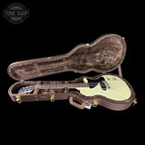 Electric guitar in a brown case with 'Tone Shop' logo.