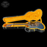 Guitar in an open case with 'Tone Shop' logo in the corner