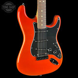 A classic electric guitar with a vibrant orange body, black pickguard, and maple neck, shown against a solid black background with a Tone Shop watermark in the top left corner.