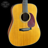 Acoustic guitar with a visible brand logo in the corner