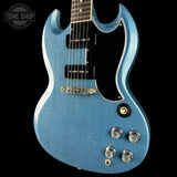 Blue electric guitar with a black pickguard on a black background, featuring the Tone Shop logo.