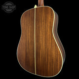 Wooden acoustic guitar body with a visible brand logo in the corner.