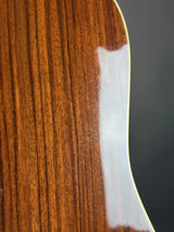 Close-up of a wooden surface with a white strip, possibly a guitar soundboard.