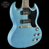 Blue electric guitar with a black pickguard on a black background, featuring the Tone Shop logo.