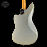 Close-up of the back of a Fender electric guitar body in a metallic silver glitter finish, with a natural wood neck visible at the top against a black background.