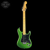Green electric guitar with a black pickguard on a white background