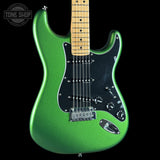 Green electric guitar with a black pickguard on a black background, featuring 'Tone Shop' logo.