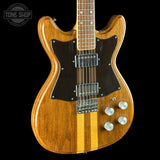 A double-cutaway electric guitar with a natural wood body, two vertical maple stripes on the lower bout, a black pickguard, and chrome hardware, shown against a solid black background.