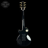 Black electric guitar with 'Tone Shop' logo in the corner