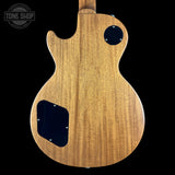 Back view of a wooden electric guitar with 'Tone Shop' logo.