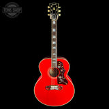 A red acoustic guitar with a decorative pickguard and gold tuning keys, shown against a solid black background with a Tone Shop watermark in the top left corner.