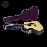 Acoustic guitar in an open case with 'Tone Shop' branding.