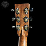 Close-up of a guitar headstock with tuning pegs on a black background, featuring the Tone Shop logo.