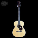 Acoustic guitar with a visible brand logo on a black background