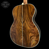 Close-up of a wooden acoustic guitar body with 'Tone Shop' logo.