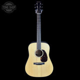 Acoustic guitar with a visible brand logo on a black background