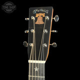 Close-up of a Martin guitar headstock with brand logo on a black background