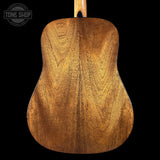Back view of a wooden acoustic guitar with 'Tone Shop' logo in the corner.