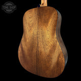 Close-up of a wooden acoustic guitar body with 'Tone Shop' branding.