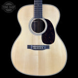 Acoustic guitar with a visible brand logo on a black background