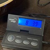 A smart weigh ACE110 digital scale with a black plastic body and a blue backlit LCD screen showing '8.39 kg'.
