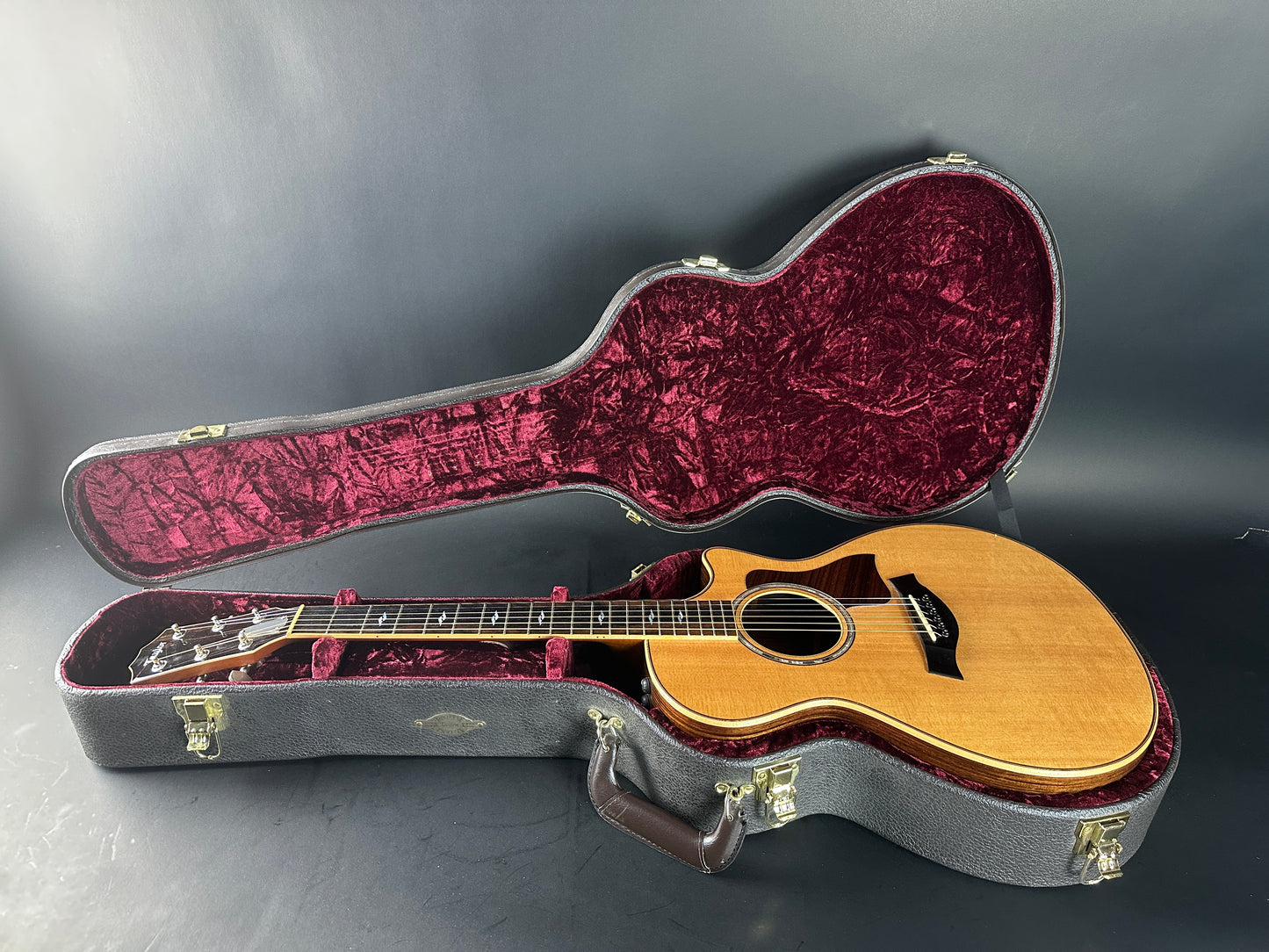Acoustic guitar in an open case on a gray background