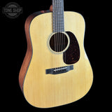 Acoustic guitar with a visible brand logo on a black background