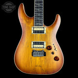 A classic electric guitar with a sunburst finish, featuring a black neck, dual humbucker pickups, and a black bridge, set against a solid black background with a Tone Shop watermark in the top left corner.