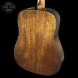 Close-up of a wooden acoustic guitar on a black background with 'Tone Shop' logo.