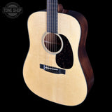 Acoustic guitar with a visible brand logo on a black background