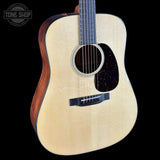 Acoustic guitar with a visible brand logo on a black background