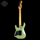 A side-view shot of an electric guitar against a solid black background, showing its light sage green body, maple neck, and black pickups. A Tone Shop watermark is visible in the top-left corner.