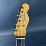 Close-up of a Fender Telecaster guitar headstock on a dark background