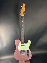 Pink electric guitar on a dark gray background