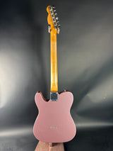 Pink electric guitar on a dark gray background